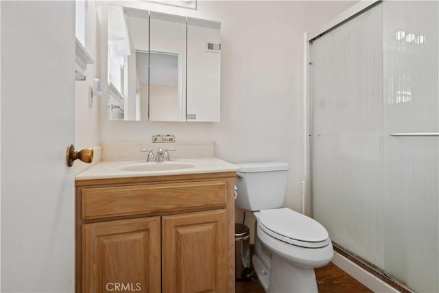 bathroom with toilet, vanity, and walk in shower