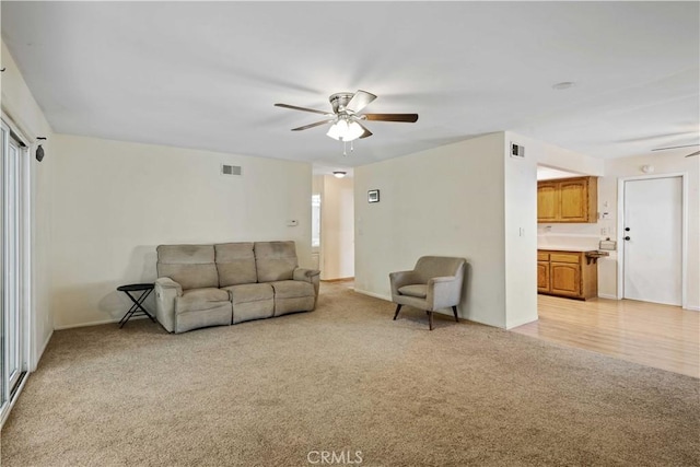 carpeted living room with ceiling fan