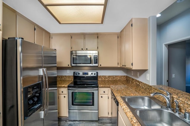 kitchen with stainless steel appliances, cream cabinets, and sink