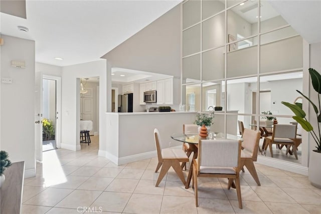 dining room with light tile patterned floors and a towering ceiling