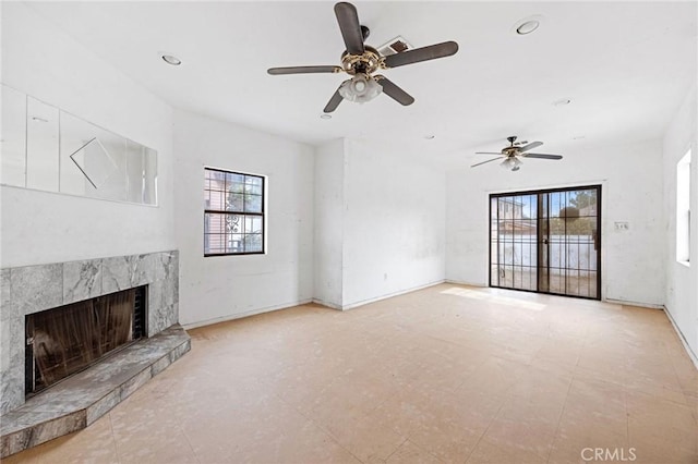 unfurnished living room with ceiling fan and a fireplace