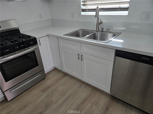 kitchen featuring white cabinets, light wood-type flooring, sink, and stainless steel appliances