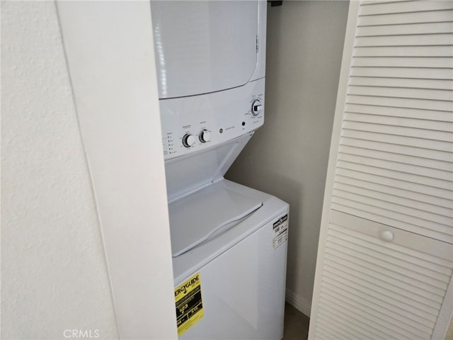 washroom featuring stacked washing maching and dryer