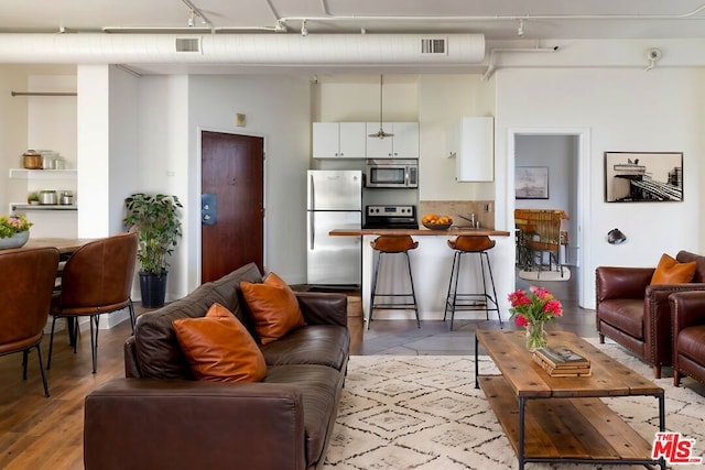 living room featuring rail lighting and sink