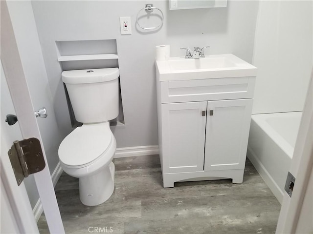 bathroom featuring a bath, vanity, and toilet