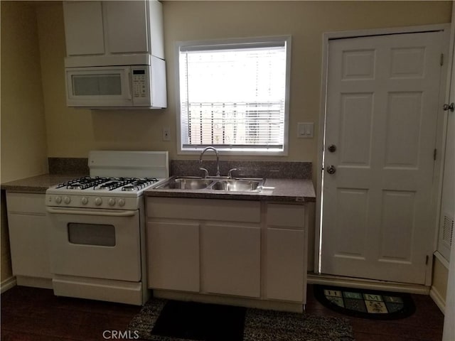 kitchen with white cabinets, white appliances, a wealth of natural light, and sink