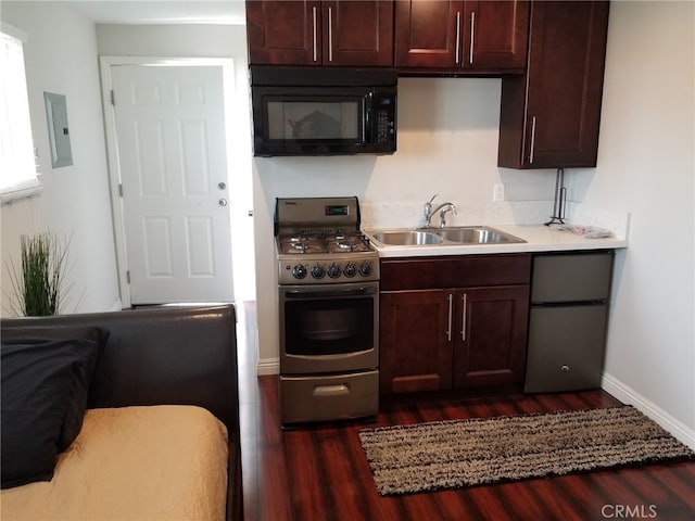 kitchen featuring sink, stainless steel gas range, dark hardwood / wood-style flooring, electric panel, and fridge