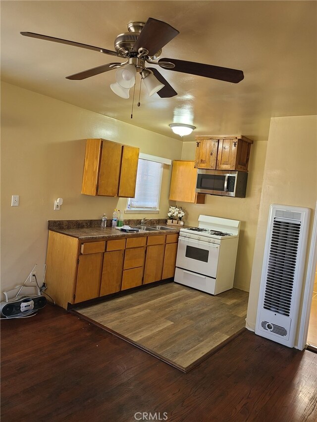 kitchen with ceiling fan, white gas stove, dark hardwood / wood-style floors, and sink