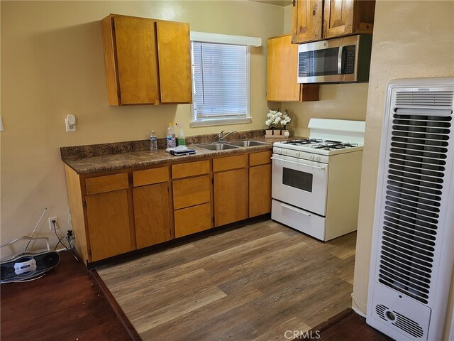 kitchen with dark hardwood / wood-style flooring, white gas range, and sink