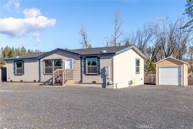 view of front of house with a garage and an outbuilding