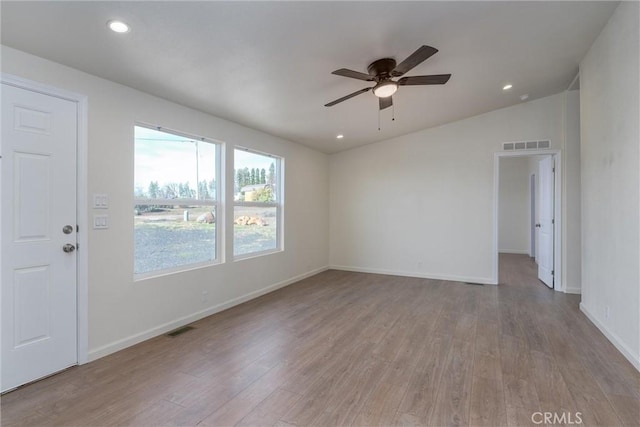 spare room with ceiling fan, light wood-type flooring, and vaulted ceiling