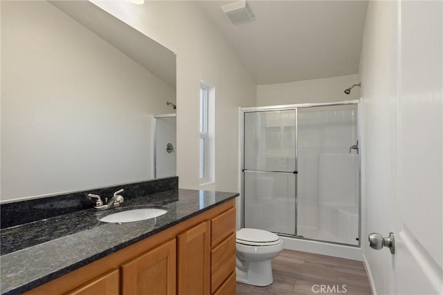 bathroom featuring toilet, vanity, vaulted ceiling, walk in shower, and wood-type flooring