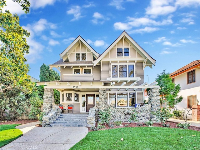 craftsman house featuring covered porch and a front yard