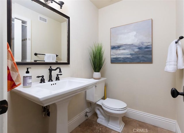 bathroom with toilet and tile patterned floors