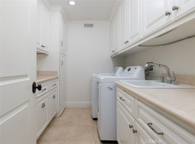 laundry room with light tile patterned floors, sink, washer and dryer, and cabinets