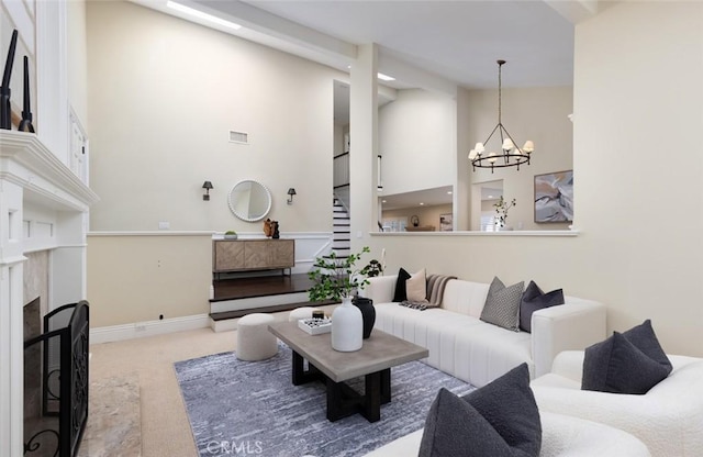 carpeted living room with a premium fireplace, an inviting chandelier, and a high ceiling