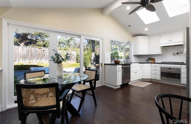 kitchen with backsplash, appliances with stainless steel finishes, white cabinetry, and lofted ceiling with skylight