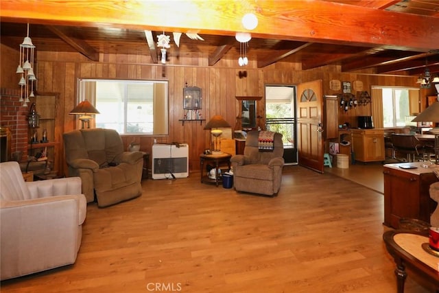 living room with wood ceiling, heating unit, beamed ceiling, and wooden walls