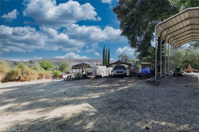 view of parking / parking lot with a mountain view and a carport