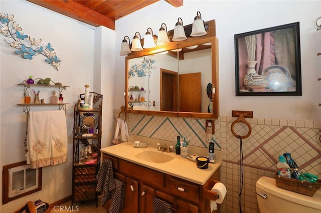 bathroom with wooden ceiling, toilet, vanity, and beam ceiling