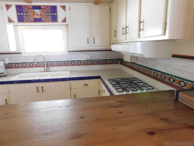 kitchen featuring sink, white cabinets, gas stovetop, and exhaust hood