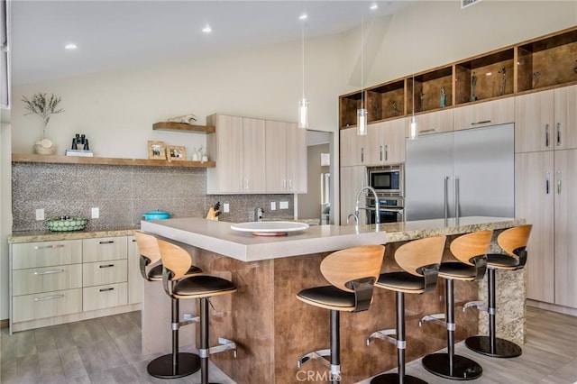 kitchen featuring built in appliances, a kitchen bar, light countertops, decorative backsplash, and open shelves
