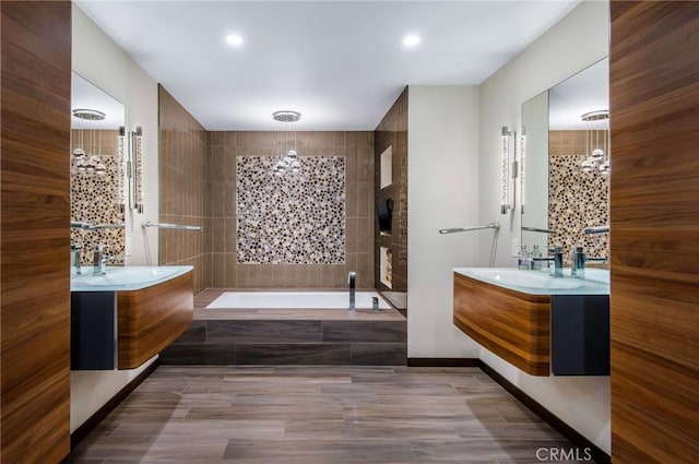 bathroom featuring vanity and a relaxing tiled tub