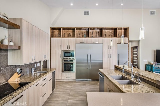 kitchen with sink, light brown cabinets, and built in appliances