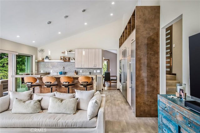 living room featuring stairway, recessed lighting, a wealth of natural light, and high vaulted ceiling