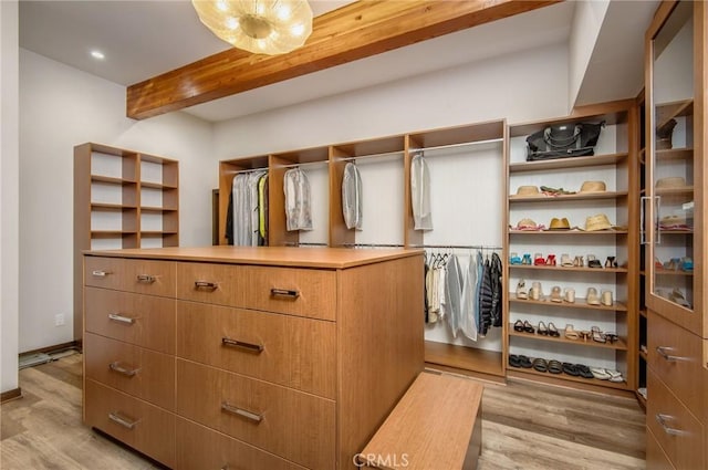 spacious closet with light wood-type flooring and beamed ceiling