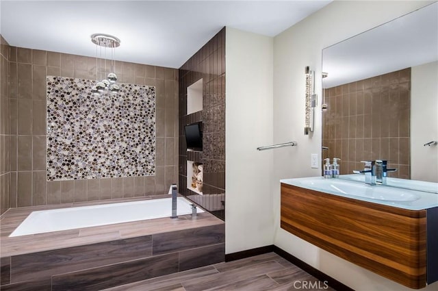 bathroom featuring baseboards, a garden tub, tile walls, and vanity