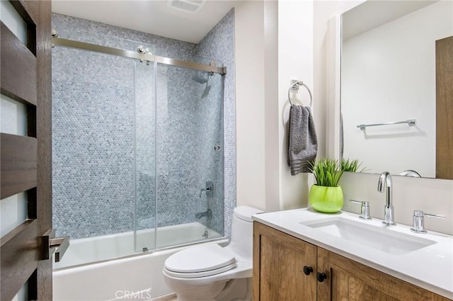 full bathroom featuring bath / shower combo with glass door, toilet, and vanity