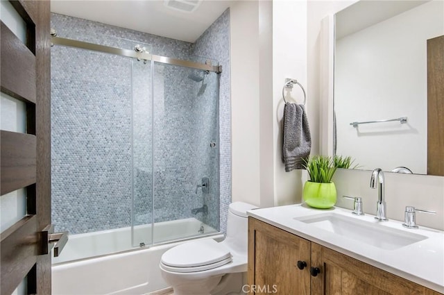 full bathroom with vanity, toilet, and combined bath / shower with glass door