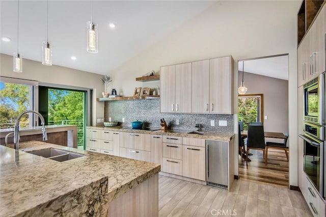 kitchen with appliances with stainless steel finishes, tasteful backsplash, hanging light fixtures, and sink