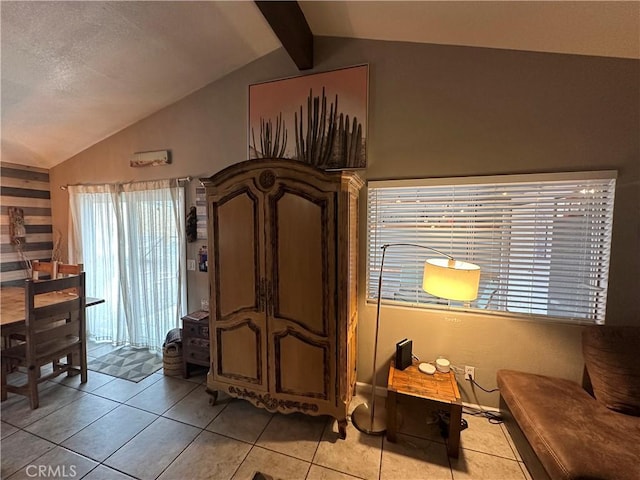 sitting room with light tile patterned floors, lofted ceiling with beams, and a textured ceiling