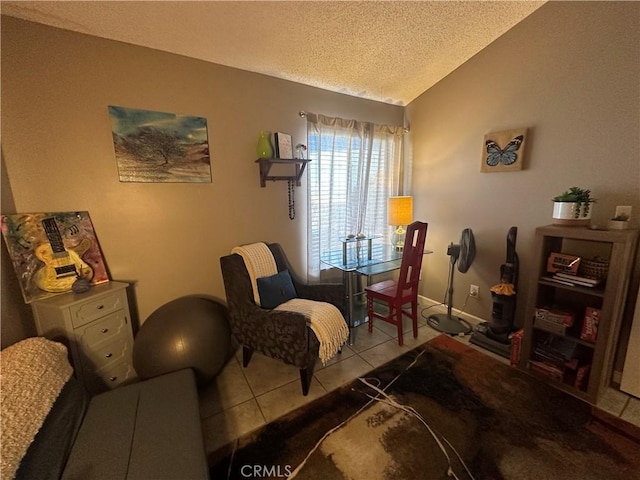 sitting room with lofted ceiling, light tile patterned floors, and a textured ceiling