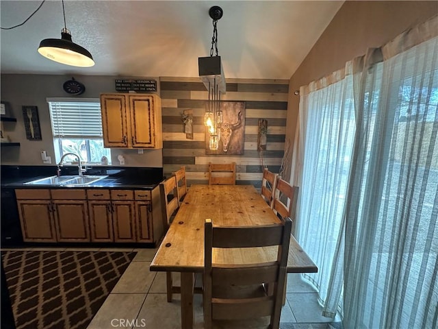 kitchen with vaulted ceiling, light tile patterned flooring, pendant lighting, and sink