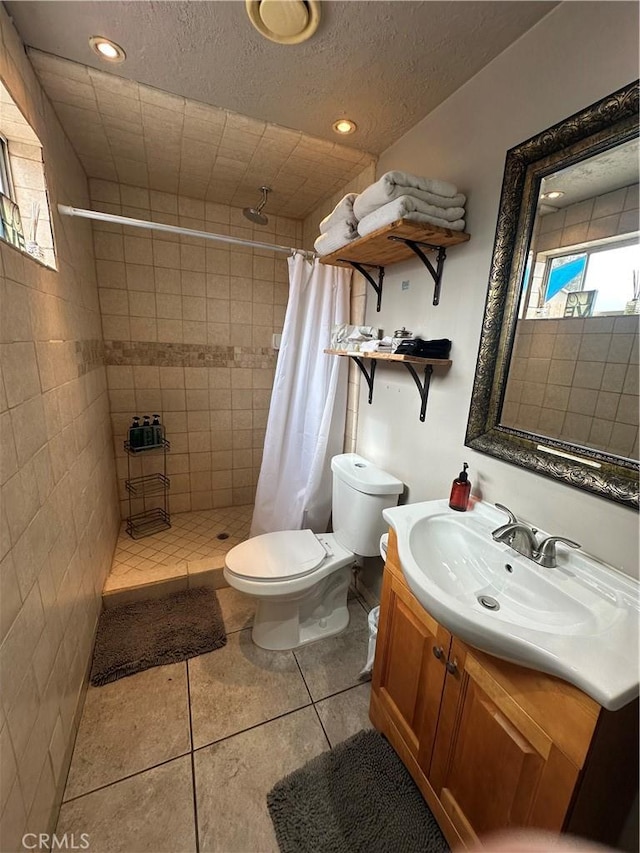 bathroom featuring toilet, tile patterned flooring, walk in shower, a textured ceiling, and vanity