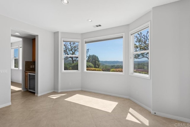 empty room with light tile patterned floors and a mountain view