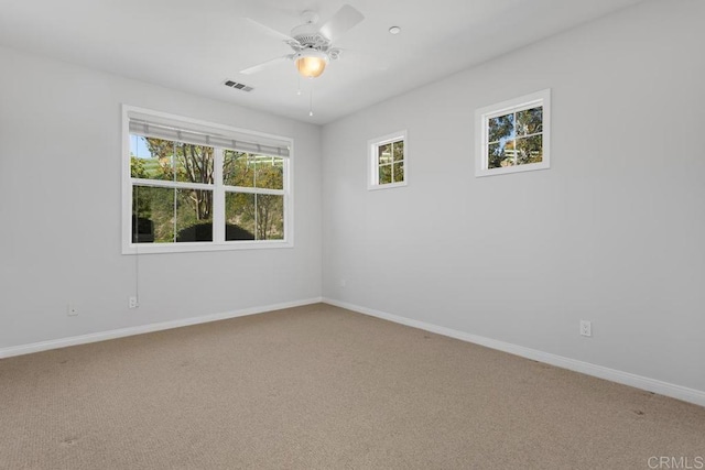 carpeted spare room featuring ceiling fan