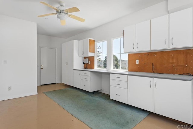 kitchen featuring ceiling fan and white cabinetry