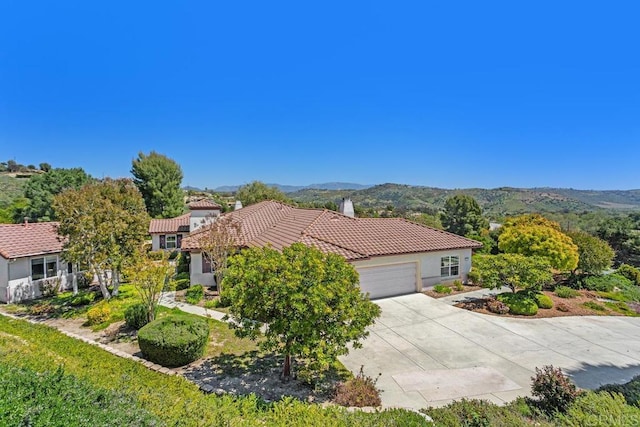 mediterranean / spanish home with a garage and a mountain view