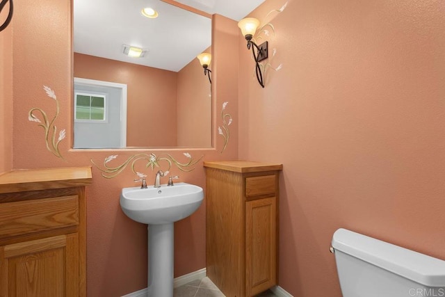 bathroom with sink, toilet, and tile patterned flooring