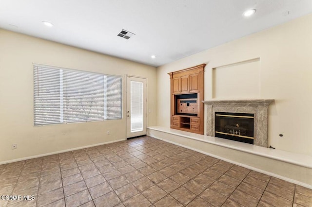 unfurnished living room with a premium fireplace