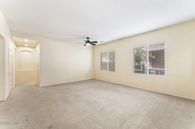 carpeted spare room featuring ceiling fan