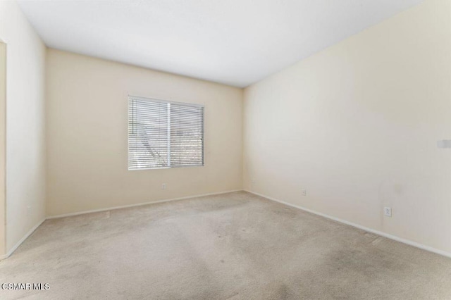 spare room featuring light colored carpet