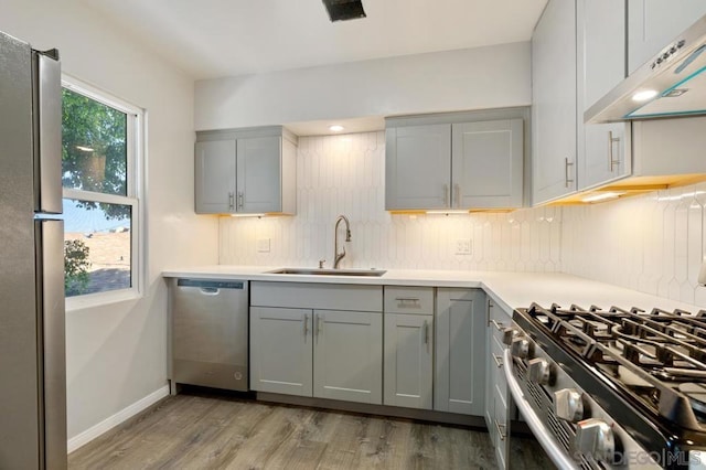 kitchen featuring gray cabinetry, sink, and appliances with stainless steel finishes