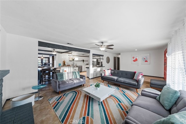 living room featuring ceiling fan, plenty of natural light, and light tile patterned floors