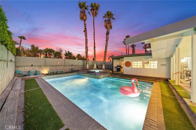 pool at dusk featuring an in ground hot tub