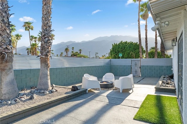 view of patio with a mountain view and an outdoor fire pit